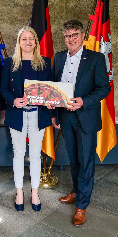 Übergabe der Einladung zum Brokser Heiratsmarkt 2026 an Dr. Kathrin Wahlmann.